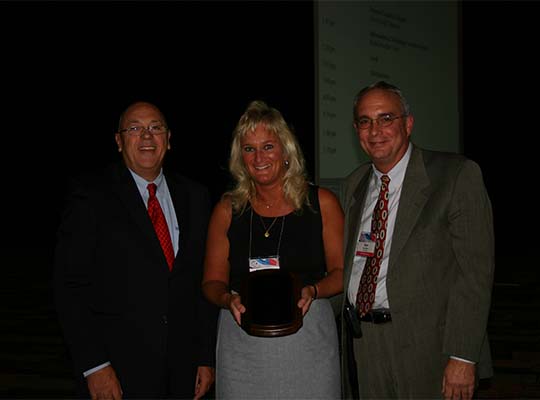 Rose Ann Bisch (MN) receives the Executive Director Award from Harry Hageman (Executive Director) with Chair Ken Merz (MN) at the 2009 Annual Business Meeting in Reno, NV.
