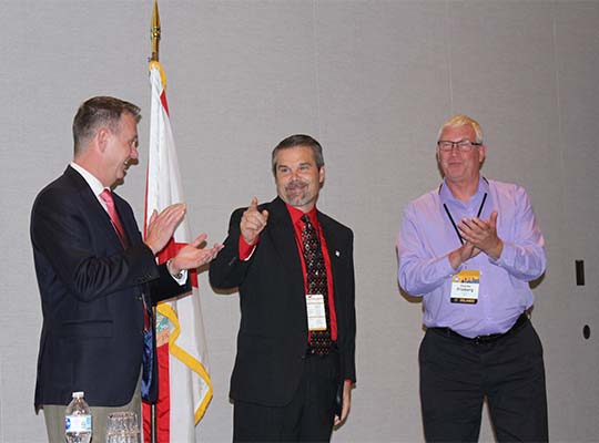 Jeremiah Stromberg (OR) congratulates Doug Clark (SD) and Chuck Freiburg (SD) at the 2018 Annual Business Meeting in Orlando, FL.