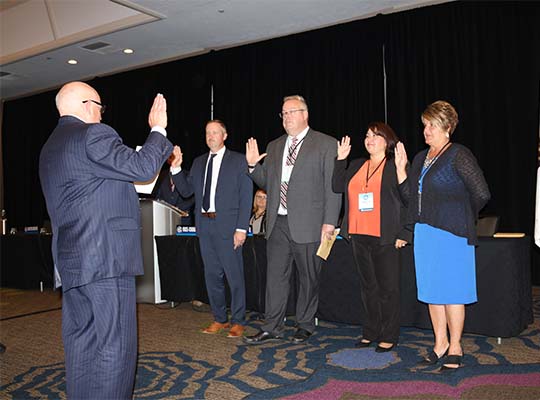 Rick Masters swears in a stellar group of region chairs, Russ Marlan (MI), Dale Crook (VT), Roberta Cohen (NM), and Julie Kempker (MO). (2019)