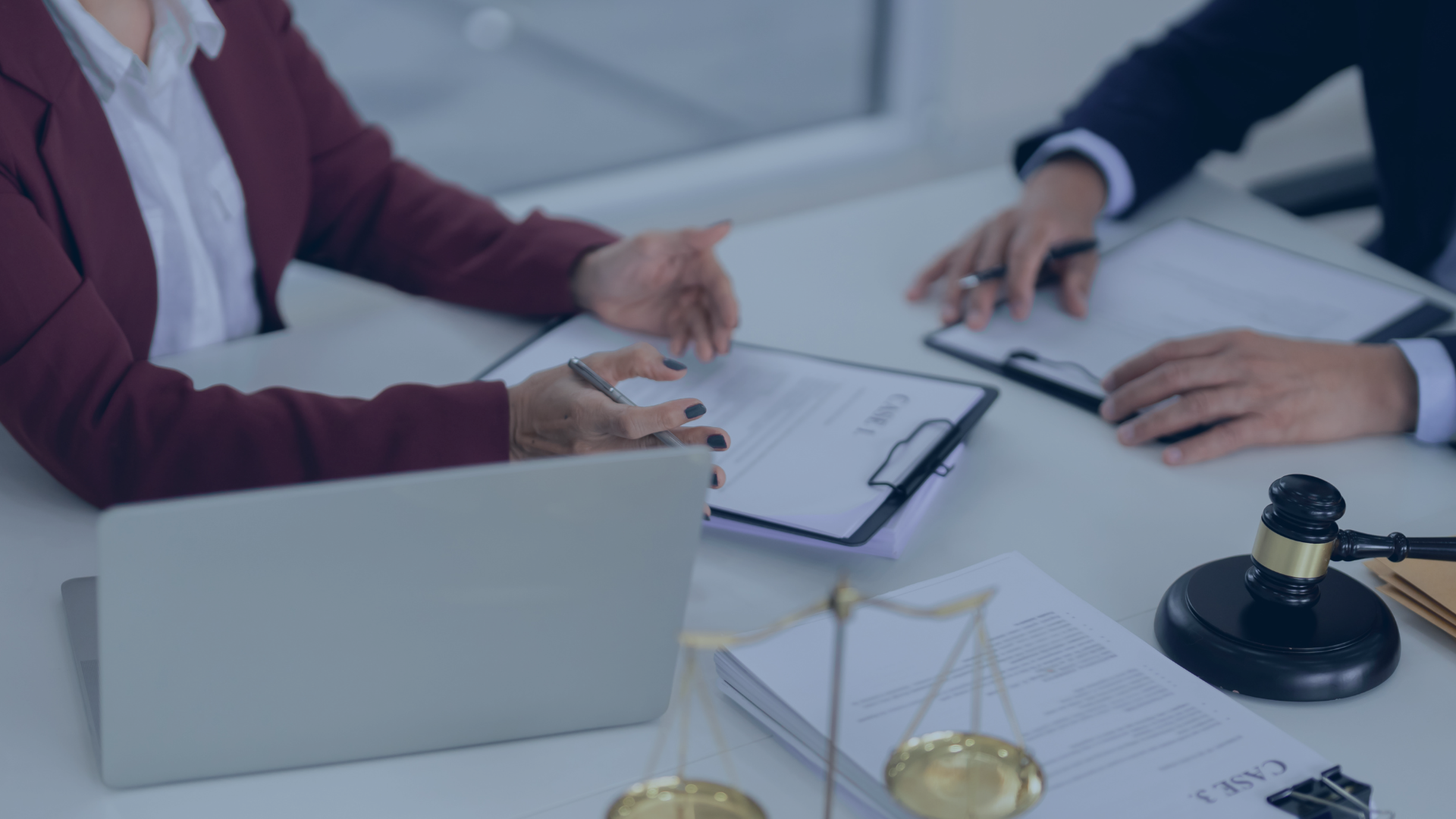 two people at a table looking over cases with a blue overlay